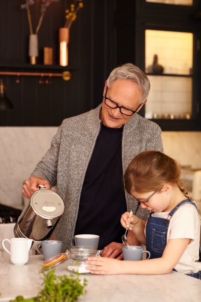 A grandpa and his granddaughter having tea.