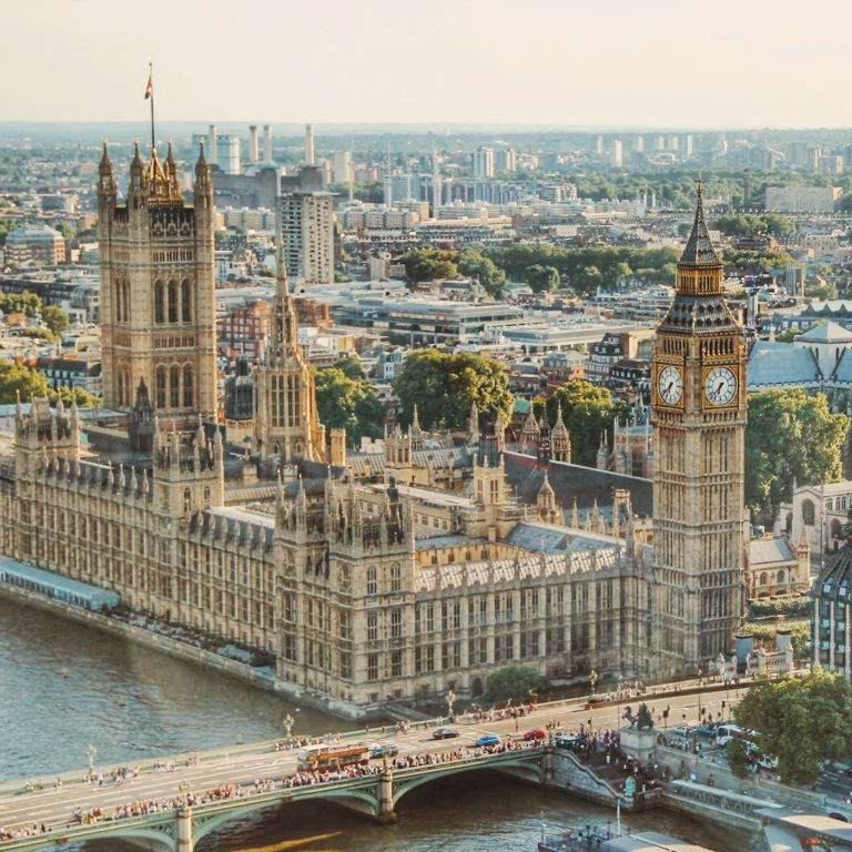 A panoramic view of London featuring Big Ben and the Palace of Westminster, showcasing the iconic architecture against the city skyline.