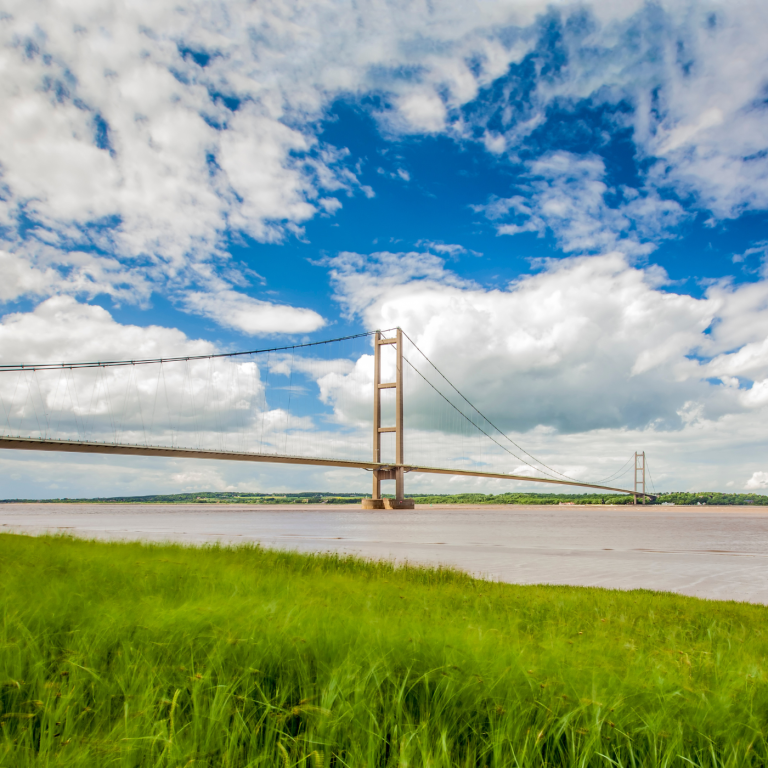 Atmospheric photograph of the Humber Bridge taken from the Barton upon Humber viewing point in England, showcasing the bridge's iconic structure.